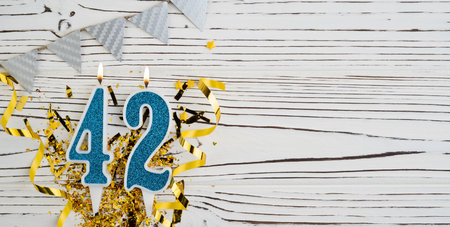 Number 42 blue celebration candle on white wooden background. happy birthday candles. Concept of celebrating birthday, anniversary, important date, holiday. copyspace. Bannerの写真素材
