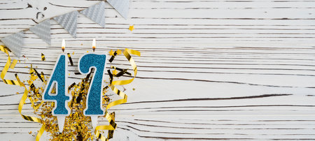 Number 47 blue celebration candle on white wooden background. Happy birthday candles. Concept of celebrating birthday, anniversary, important date, holiday. Copy space.の写真素材
