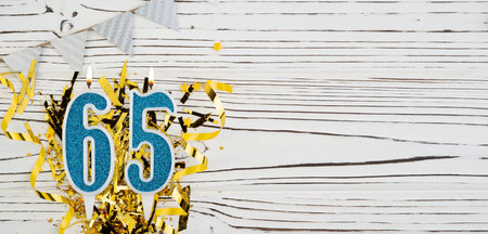 Number 65 blue celebration candle on white wooden background. Happy birthday candles. Concept of celebrating birthday, anniversary, important date, holiday. Copy space.の写真素材