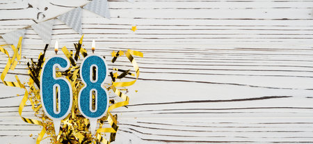 Number 68 blue celebration candle on white wooden background. Happy birthday candles. Concept of celebrating birthday, anniversary, important date, holiday. Copy space.の写真素材
