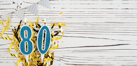 Blue candle number, digit eighty. Birthday greeting card with inscription 80. Anniversary concept. Top view. Numeral on wooden white background. Numerical digit, Celebration event.の写真素材