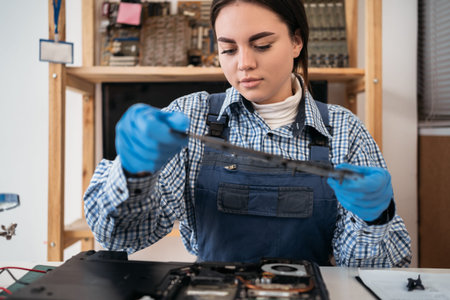 Repairman holding the laptop case for its repair and maintenance. Repair and maintenance of laptops. Selective focus.の写真素材