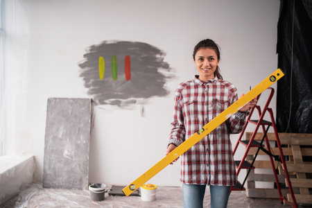 Woman with yellow bubble level tool. Human holding building and engineering measure equipment.の写真素材