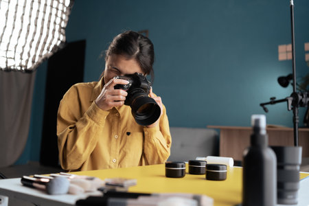 Professional photographer taking photo of cosmetic products on desktop, using camera and natural light Indoors. Blogging, profession and people conceptの写真素材
