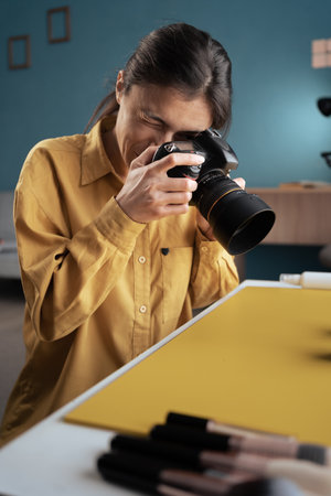 Photographer photographing beauty products on table in home studio. Professional Photography, Modern arts and creative career concept.の写真素材