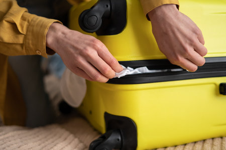 Preparation travel suitcase at home. Close up of handsの写真素材