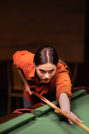Playing billiard. Portrait of a woman playing billiard