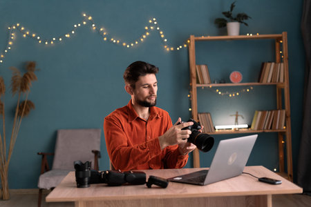 Young man photographer work from home using technology editing photo with laptop. Creative male focusing on freelance work. Business people concept.の写真素材