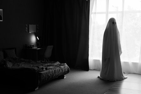 Silhouette of ghost in window inside bedroom at night. Horror scene. Halloween concept.の写真素材