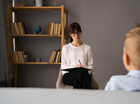 Depressed teen visiting psychologist with problems awkward age. Children psychologyst.の写真素材