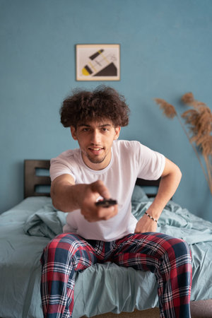 Arabic man watching TV wake up in the morning uses remote control
