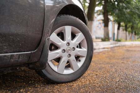 Close up of a black car tire park on the road. Car wheels, low profile tires on aluminum rimsの写真素材
