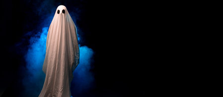 Scary ghost covered in sheet on a dark background in the smoke. Halloween poster.の写真素材