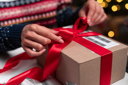 Merry Christmas shipping delivery concept. Santa Claus packing present box wrapping gift with red...
