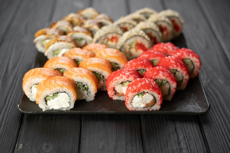 Sushi set on black background, variety of sushi rolls on black stone, sushi menu concept.の写真素材