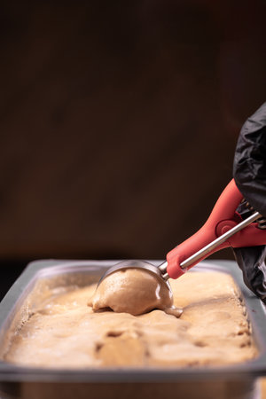 Close-up of chocolate ice cream scoop out of the container with a spoon.の写真素材