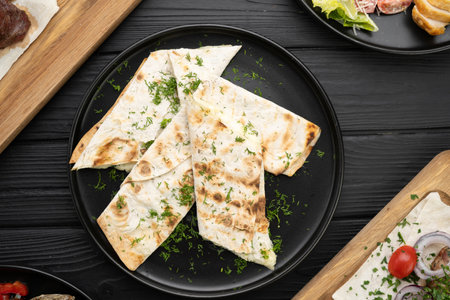 Suluguni grilled cheese in dough on black plate over wooden background, top viewの写真素材