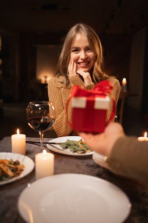 Romantic candlelight dinner for two, Valentines Day date, man giving a gift to woman, romantic family relationship, Valentines day celebrationの写真素材