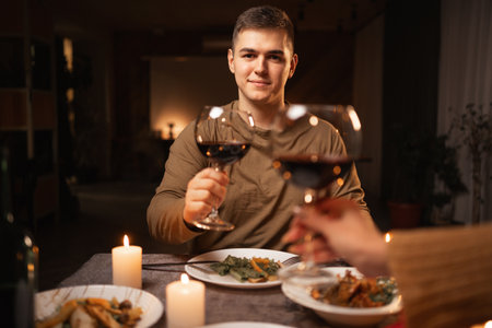 Cropped image of romantic young couple with glasses of red wine during date in restaurant or home, Love relationship celebrationの写真素材