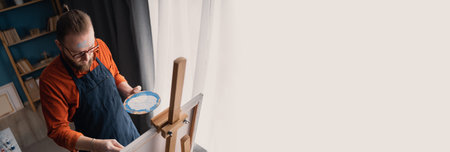 The artist in the art class as a drawing course painting on white canvas. High angle view.の写真素材