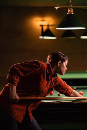 Pool billiard game in process. Woman playing in American pool billiard. Billiard sport concept.の写真素材