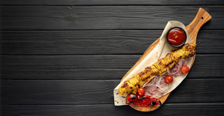 Top view on Kebabs. Grilled meat skewers, shish kebab with vegetables on Wooden background.の写真素材
