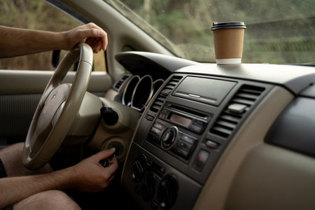 Male hand putting car key to the keyhole and starting his carの写真素材