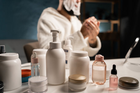 Face and hand skin care products. Daily beauty routine concept, man applying hand cream.の写真素材