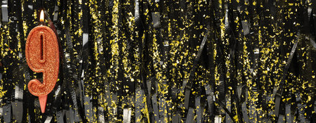 Burning red birthday candles on dark glitter background, number 9