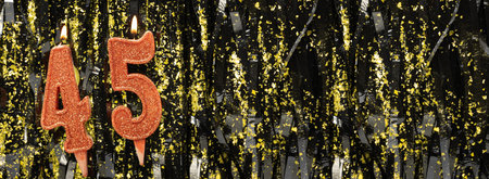 Burning red birthday candles on glitter tinsel background, number 45. Banner.