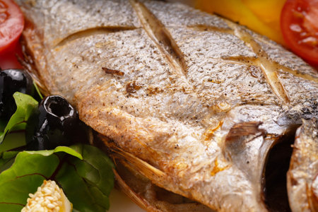Baked dorado fish with vegetables, seafood concept. Macro shot.