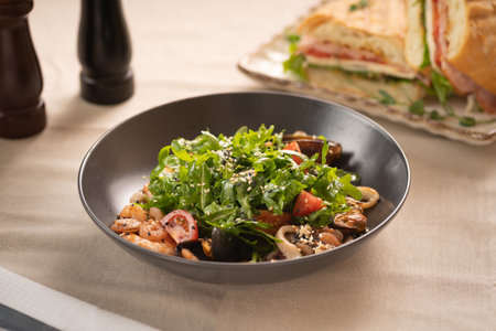 Fresh salad plate with shrimp, tomato and arugula on wooden table. Healthy food.の写真素材