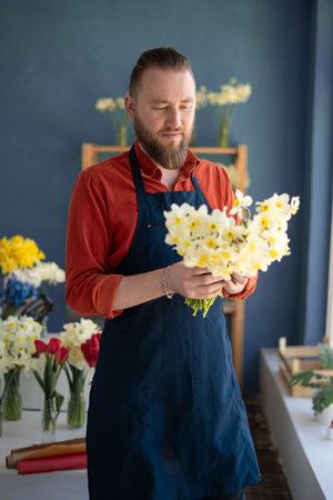 Florist shop. Man holding beautiful bouquet of flowers. Florist with his work.の写真素材