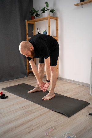 Athletic man doing sport, bending and stretching hands out, warming up training muscles for...