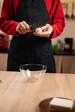 Man breaking eggs into glass bowl for Christmas baking preparation
