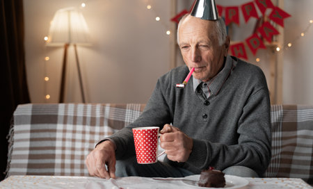 Lonely forgotten by children old man celebrating birthday alone at homeの写真素材