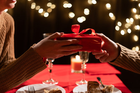 Valentines Day concept. Happy couple in love celebrating Valentines Day in the restaurant. Man give gift to his wife.の写真素材
