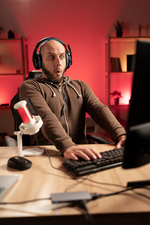 gamer wearing headphones playing video game on personal computer, play in eSport cyber games...