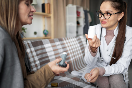 illness prevention concept. Female doctor explain drug pill dosage to mature woman with chronic senile disease.の写真素材