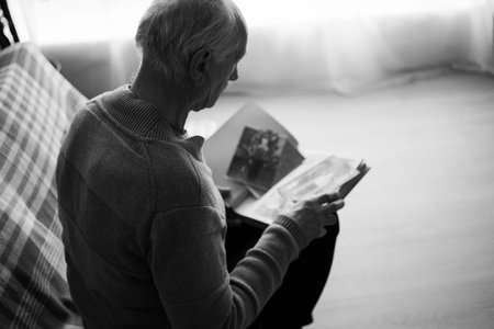Sad senior man looking old photos. Loneliness and depression on retirement. nostalgia, memory and remember concept.の写真素材