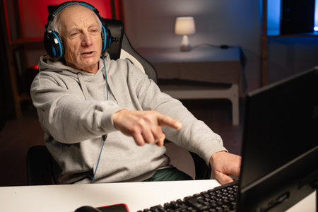 Male retired gamer streamer hosting live online video game broadcast pointing finger at screen...
