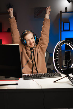 Happy Vlogger gamer broadcasts live streaming to review video game on social media, winning triumph...