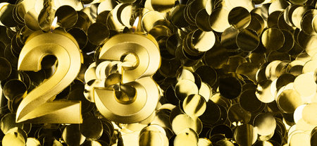 Golden number twenty-three candle on shiny yellow confetti background. Festive backdrop for twenty-third birthday, anniversary or celebration. Bright greeting card with space for text.の写真素材