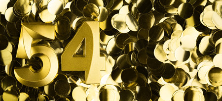 Golden number fifty-four 54 candle on shiny yellow confetti background. Festive backdrop for fifty-fourth birthday, anniversary, or celebration. Bright greeting card with space for text.の写真素材