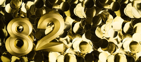 Golden number eighty-two 82 candle on shiny yellow confetti background. Festive backdrop for eighty-second birthday, anniversary, or celebration. Bright greeting card with space for text.の写真素材