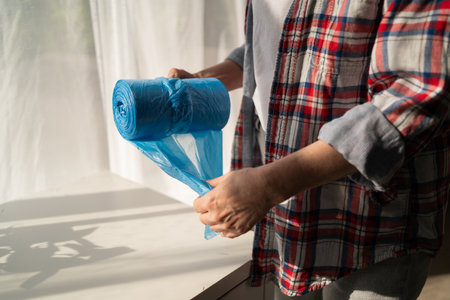 Rolls of garbage bag in female hands, close-up. Cleaning suppliesの写真素材
