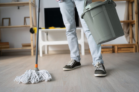 woman holding mop and bucket cleaning floor at homeの写真素材