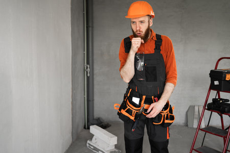 sick builder has cough, construction worker having virus, repairman suffering cold making repair in the house. Treatment and healthcareの写真素材