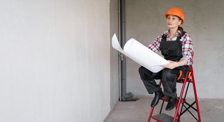 Female engineer working at construction site with project blueprint. Civil Engineer. Copy space.の写真素材