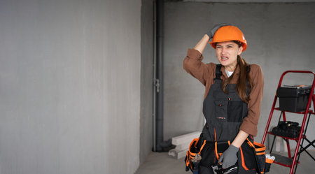 Confused upset angry woman builder holding head thinking about problem at work